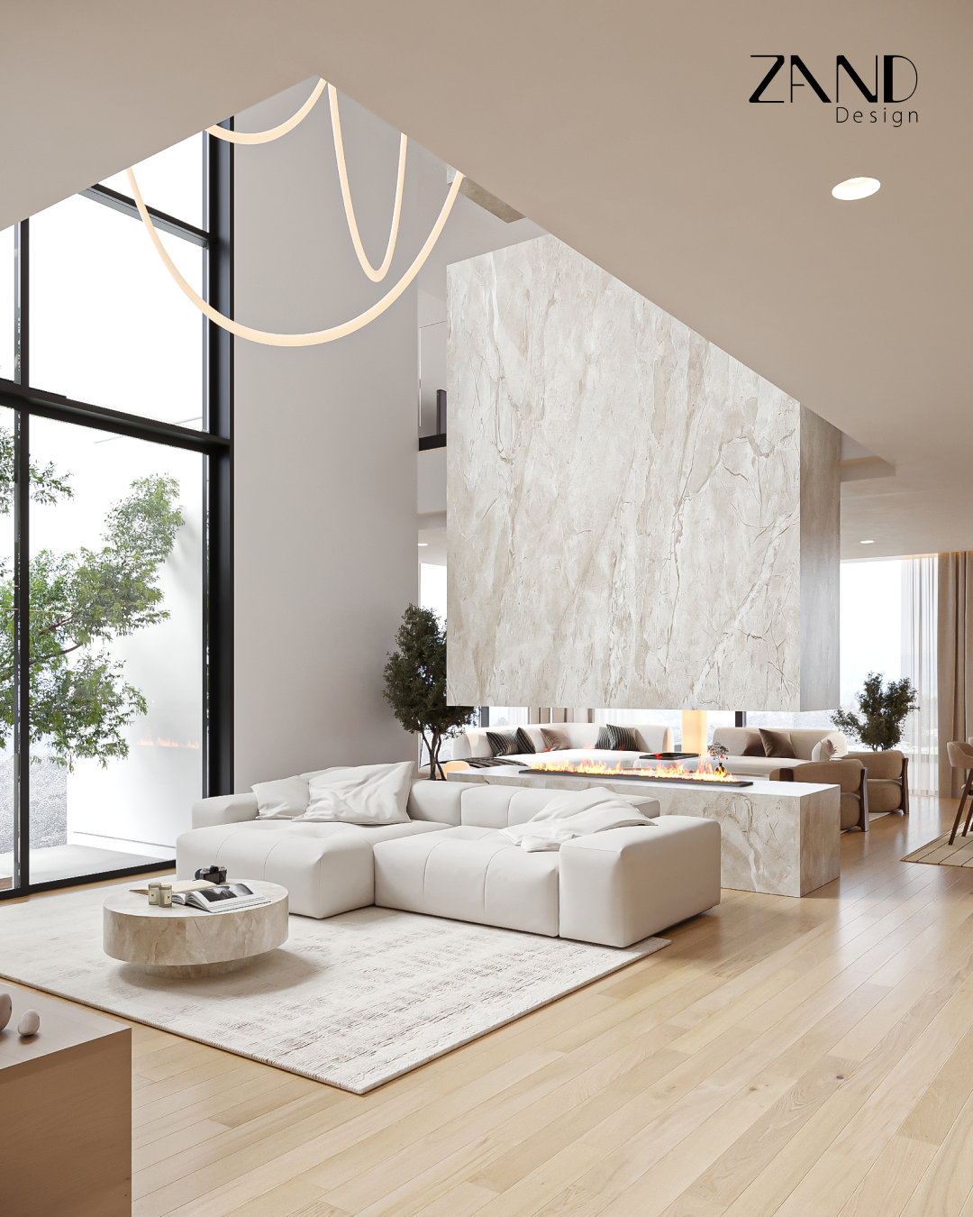 An angled view of an open-concept living space. A massive marble-textured pillar hangs above a modern linear fireplace that separates the sitting area from the rest of the home under a double-height ceiling.